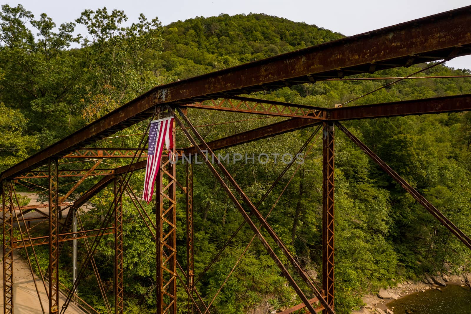 Aerial view of torn damaged Stars and Stripes flag on the historic metal truss Jenkinsburg Bridge near Morgantown