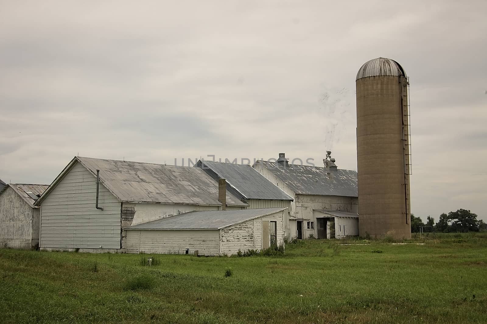 This is a group of vintage farm buildings on overcast day.