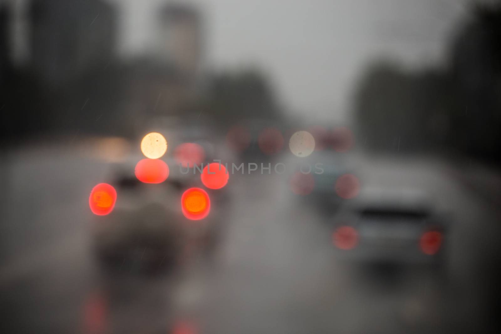 Defocused picture of evening city street car traffic after rain - view from road.