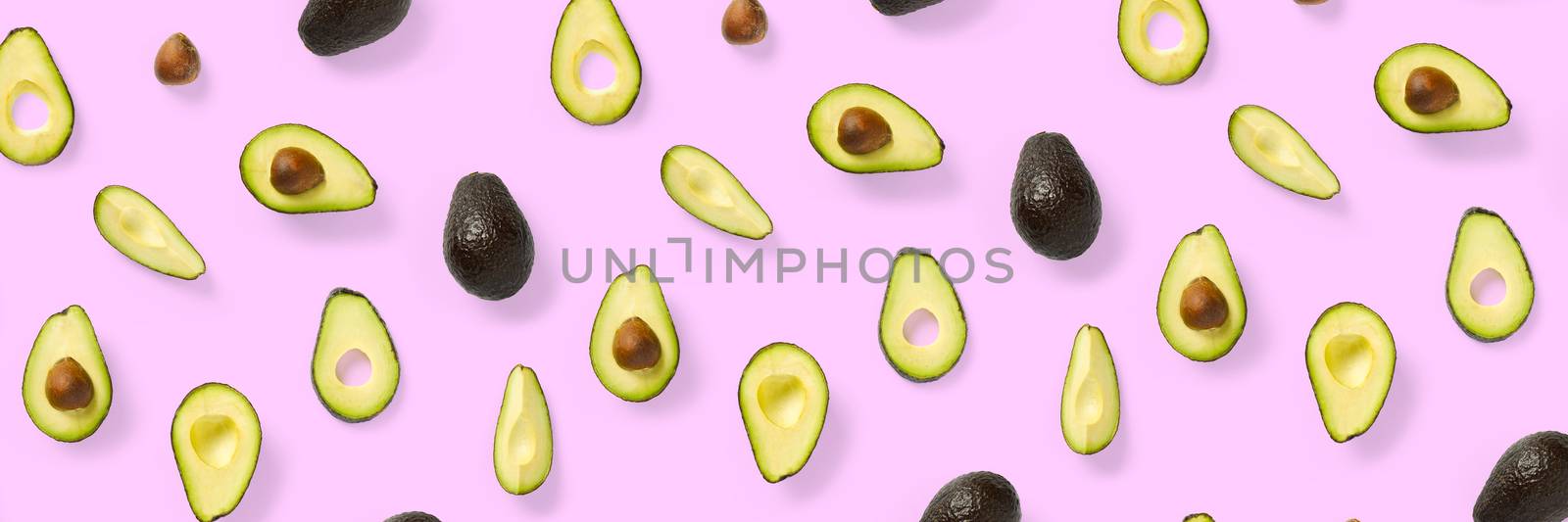 Avocado banner. Background made from isolated Avocado pieces on pink background. Flat lay of fresh ripe avocados and avacado pieces