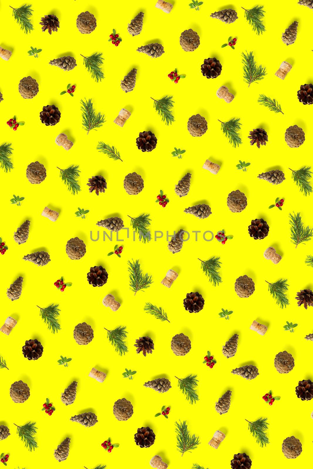 christmas background with pine cone, wine cork, pine twig and lingonberry. christmas background on yellow backdrop