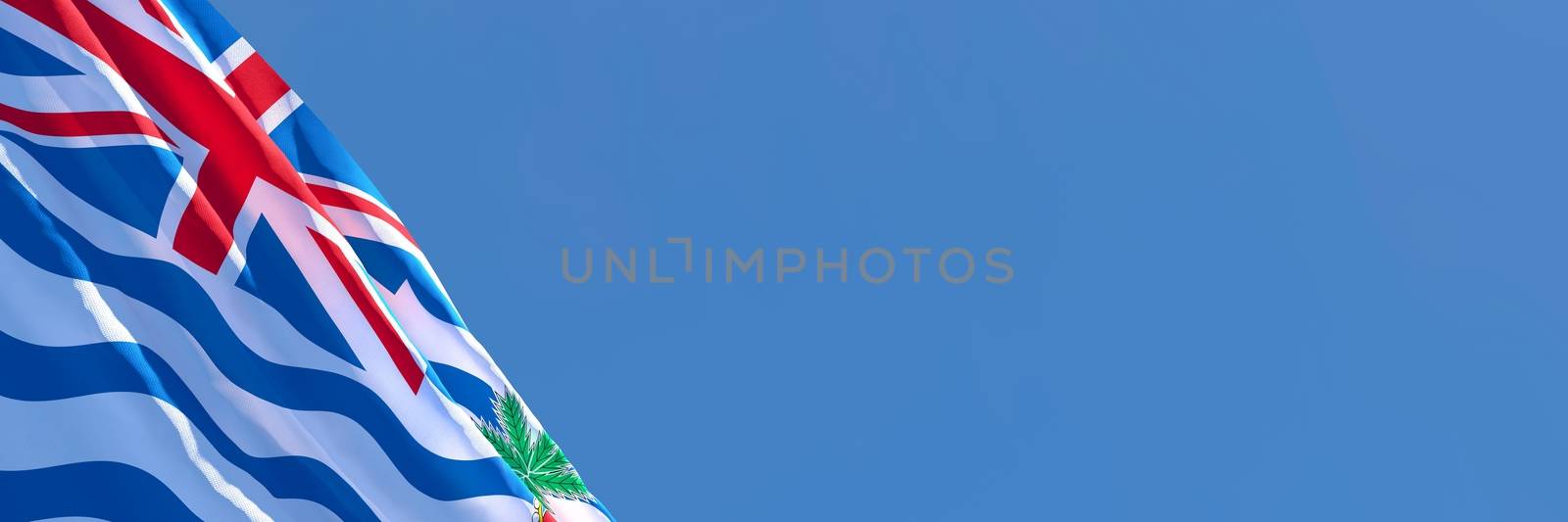 3D rendering of the national flag of British Indian Ocean Territory waving in the wind against a blue sky