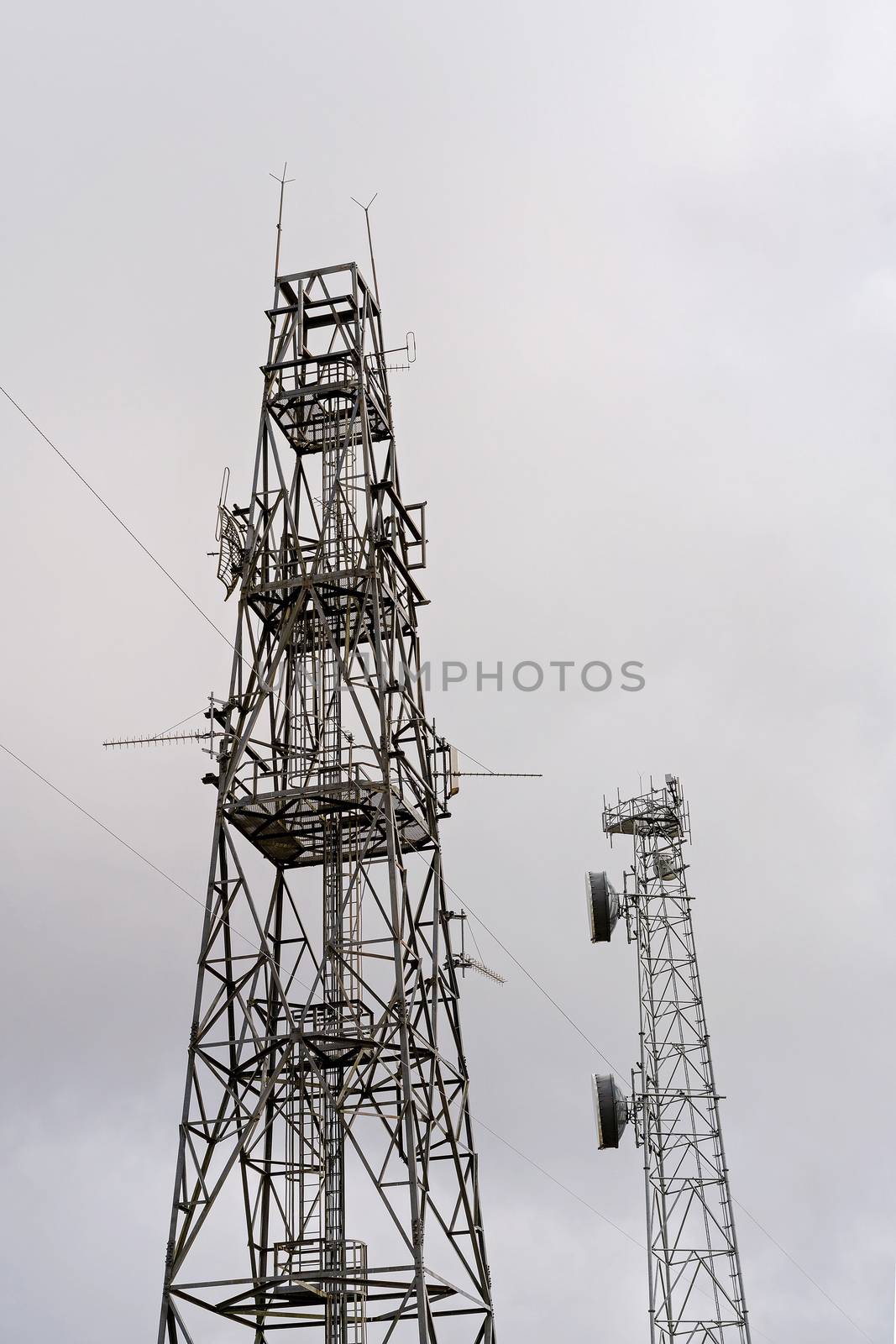 Modern technology communication towers against a bright sky