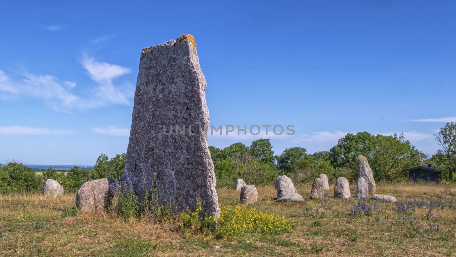 Viking stone ship burial and old windmill in Oland island by beautiful day, Gettlinge, Sweden