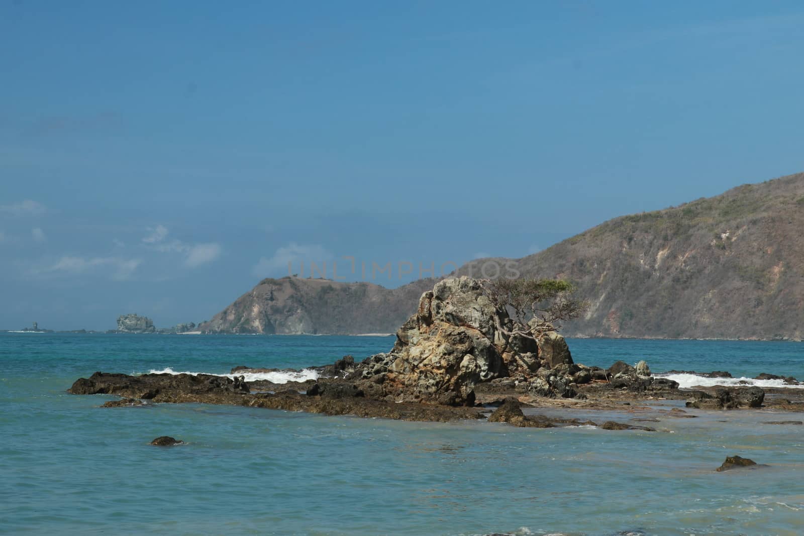 Rock formations on the beach Mandalika Kuta beach, Lombok, Indonesia. Blue sky and suuny day.