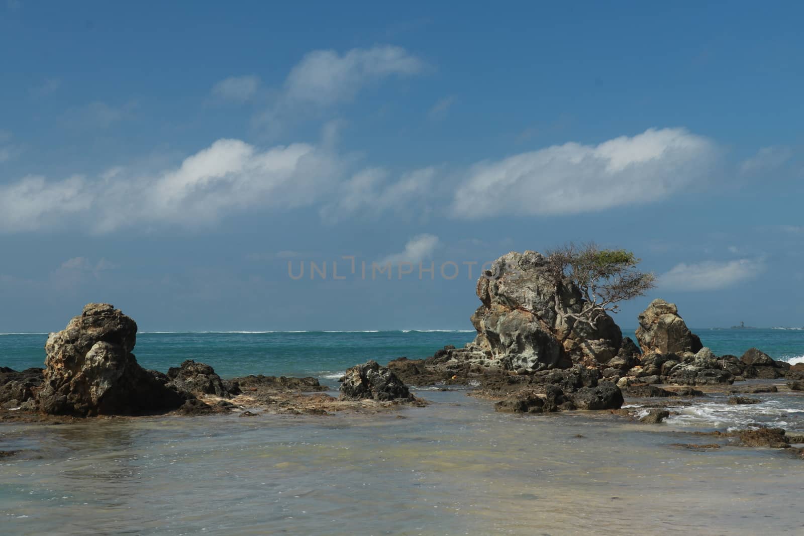 An idyllic beach in Lombok, Indonesia. The Mandalika beach is stony, with many rock formations emerging from the water. Rock formations on beach Kuta beach. Perfect day for relaxation.