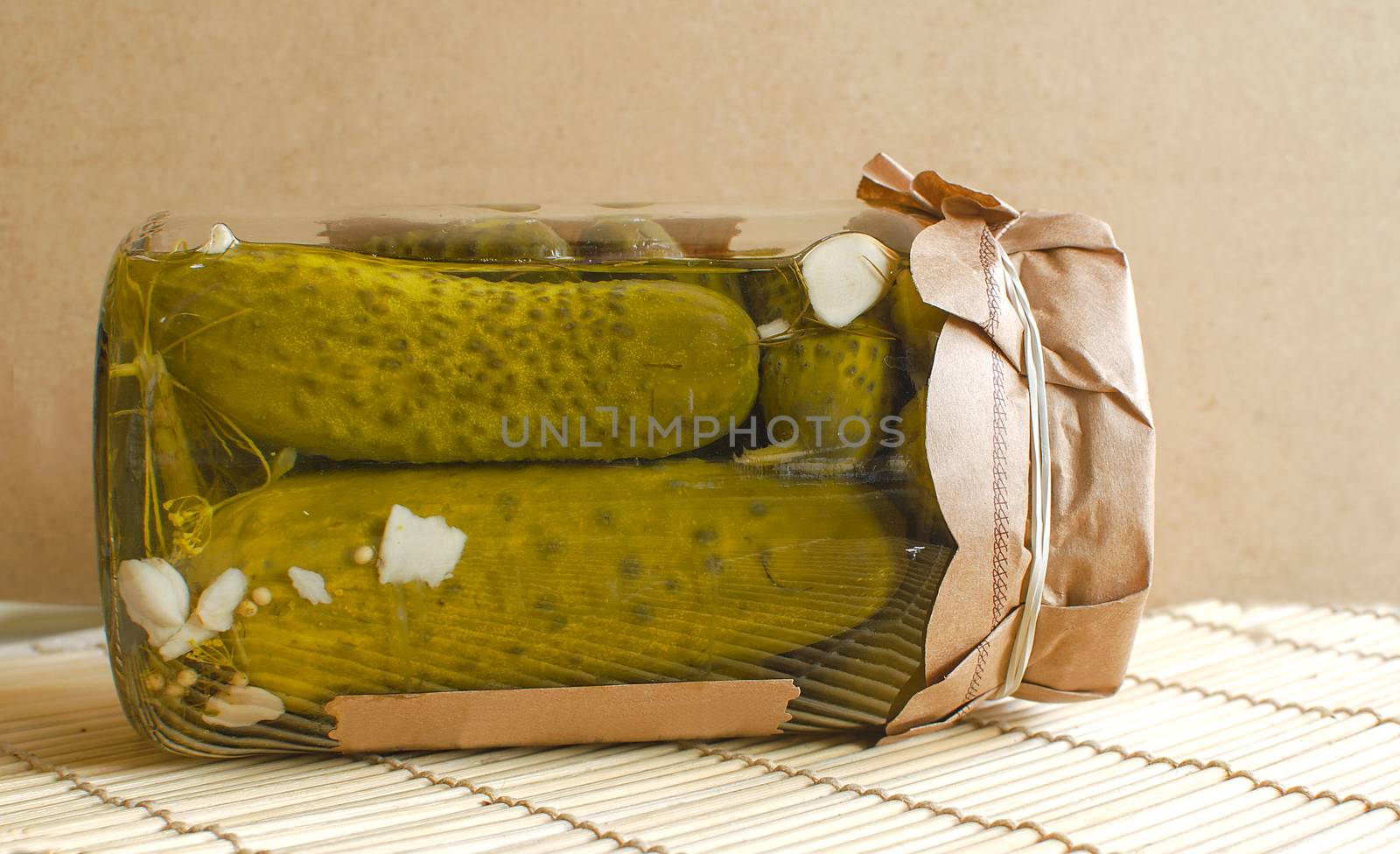 Clear glass jar of green pickled cucumbers or cornichon gherkins. Harvesting vegetables for the winter. Salted homemade food.