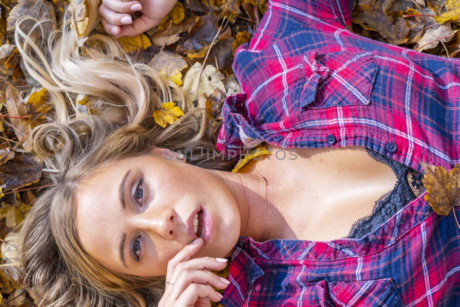 A gorgeous blonde model enjoys a Autumn day outdoors in a park