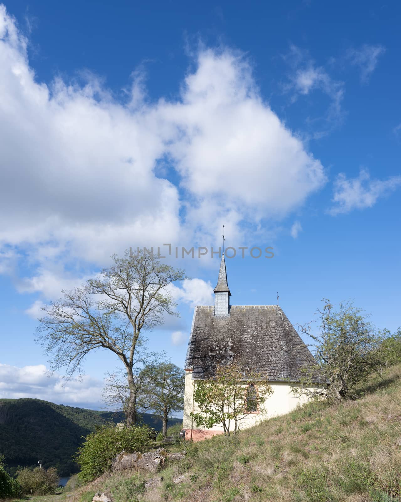 old chapel high above pommern and mosel valley in german eifel under blue sky in summer