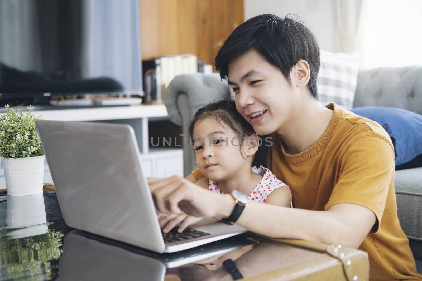 Young man and school-girl working form home and e-learning. by ijeab