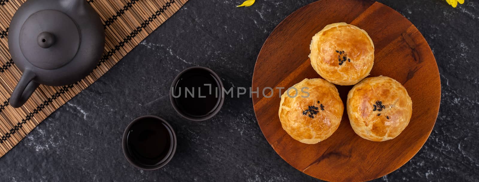 Moon cake yolk pastry, mooncake for Mid-Autumn Festival holiday, top view design concept on dark wooden table with copy space, flat lay, overhead shot