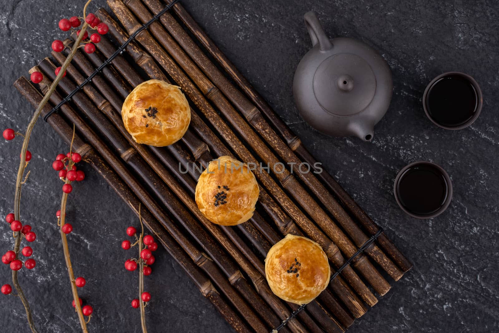 Moon cake yolk pastry, mooncake for Mid-Autumn Festival holiday, top view design concept on dark wooden table with copy space, flat lay, overhead shot