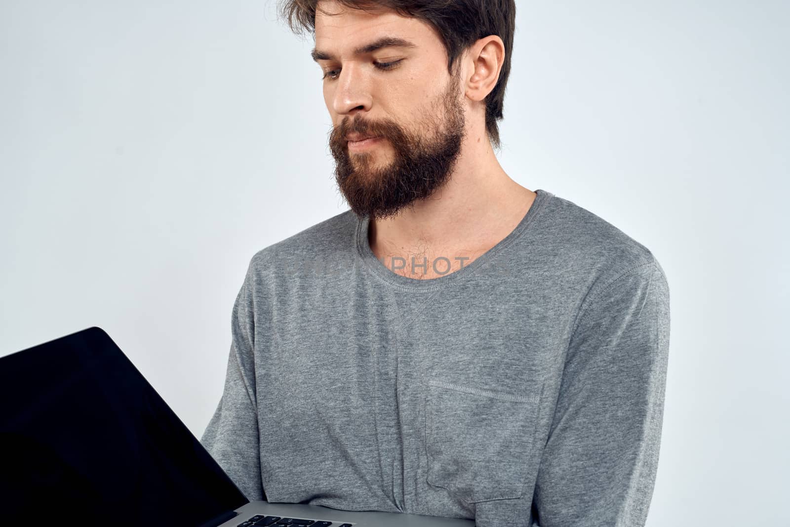 A man in a gray sweater with a laptop hands lifestyle technology communication internet work by SHOTPRIME