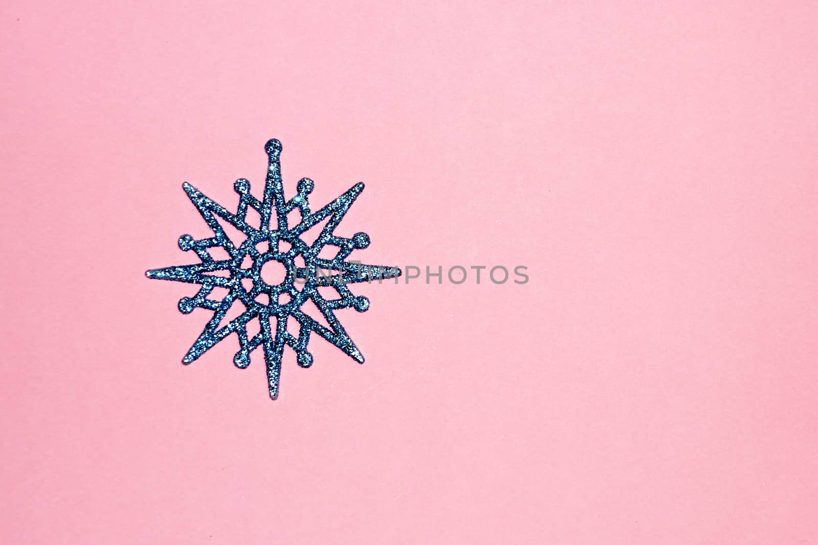 blue snowflake on pink background, copy space for christmas background.