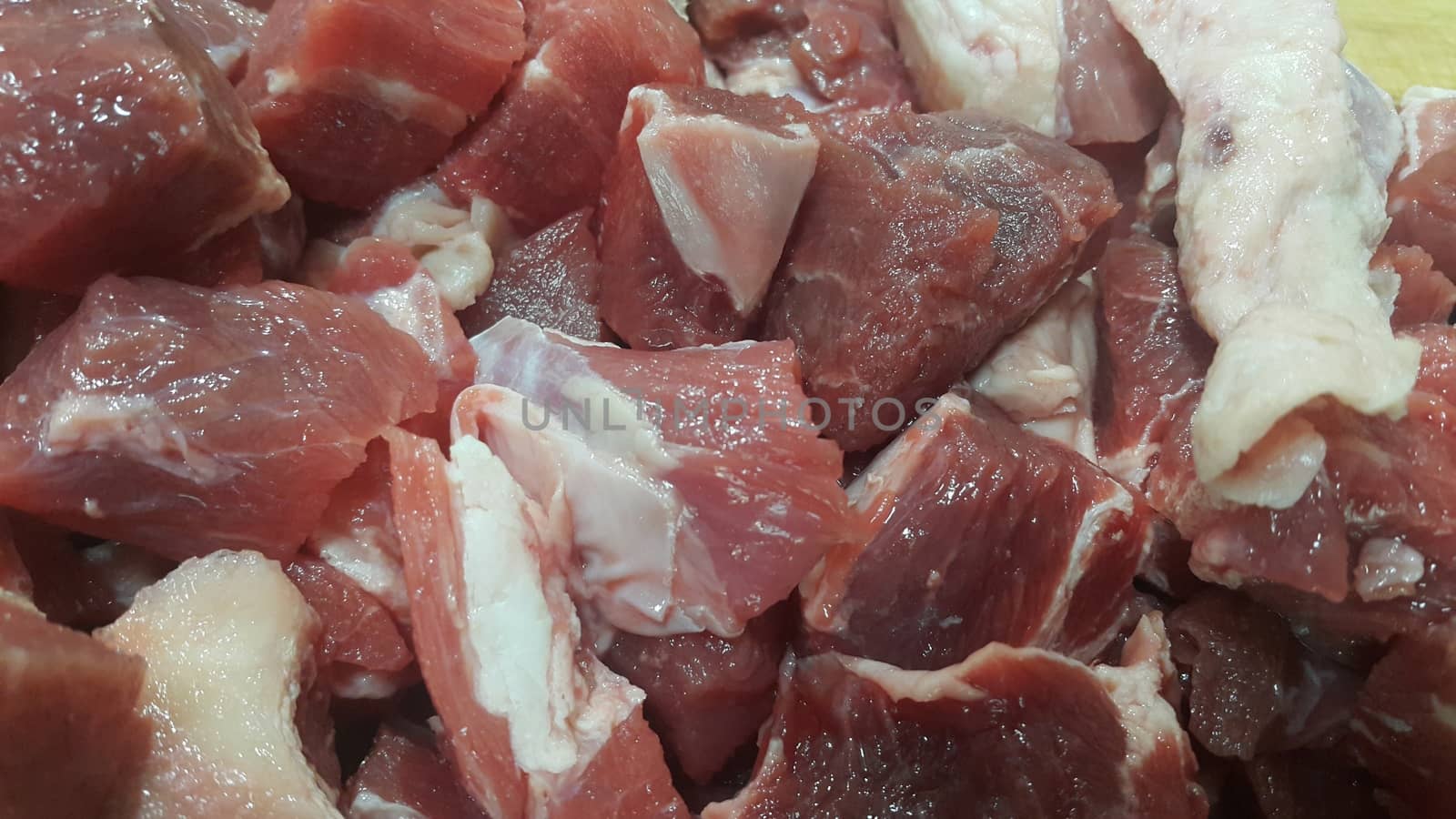 Close up view of fresh finely chopped meat cubes. Red meat small steaks with whitish meat fat.