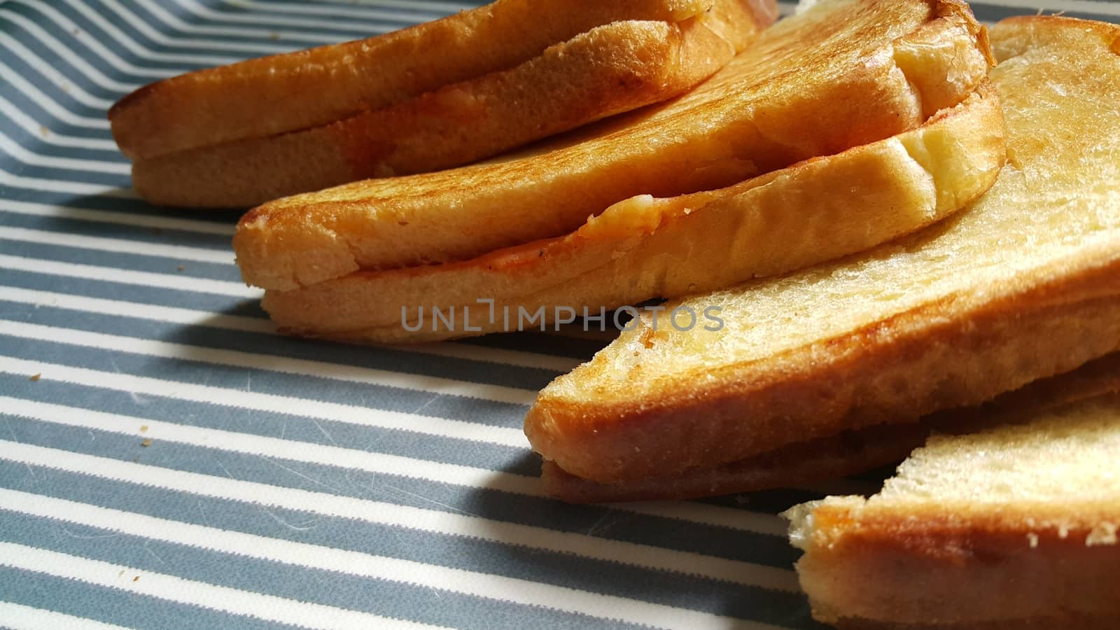 Closeup view of freshly prepared half fried slices of toast bread. Food background for bakery products