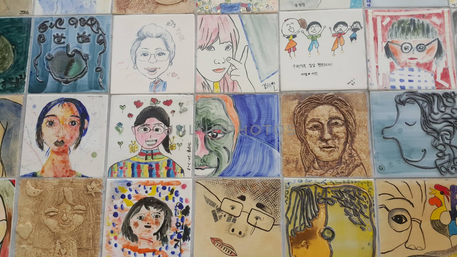 Chuncheon city hall, South Korea-March-25, 2019: Paintings and sculpted faces of people on the concrete wall for memoir in a public park.