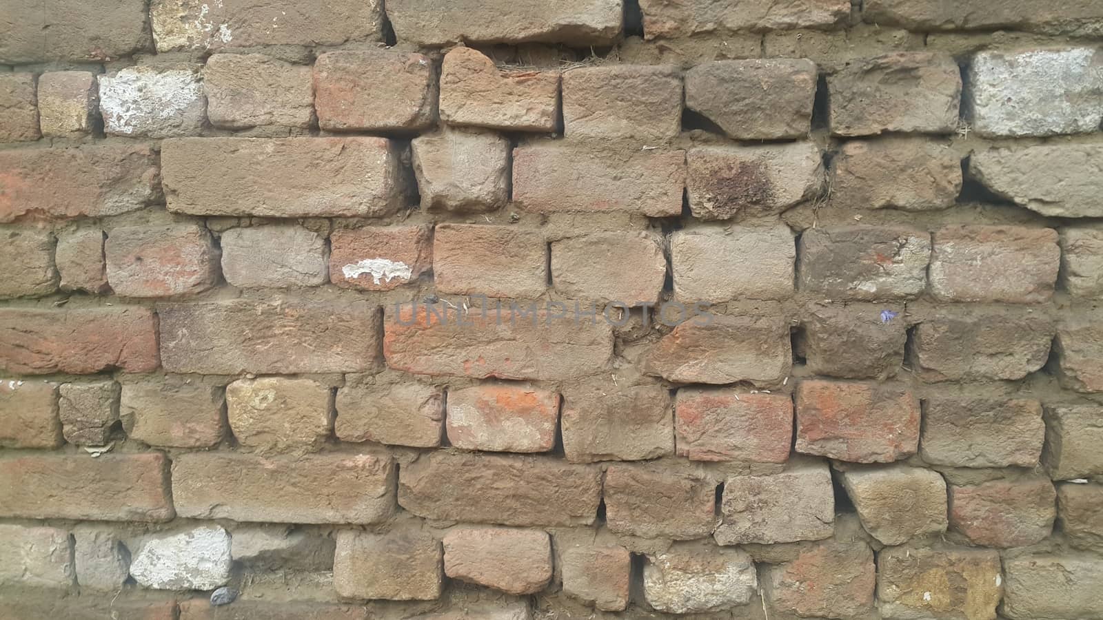 Closeup texture of red brick wall. A background of a weathered old exterior brick wall in the sunshine.