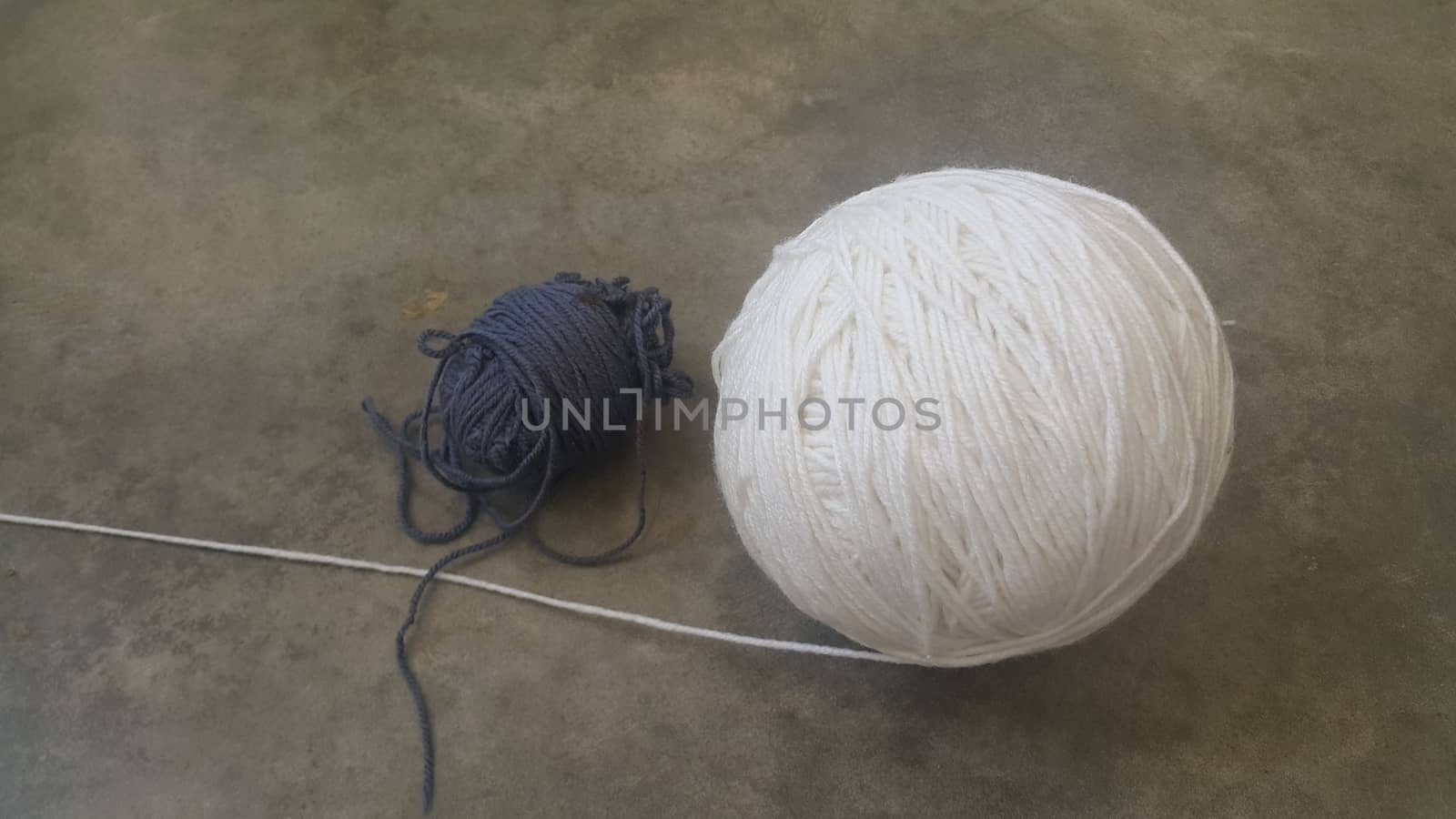 Colorful ball of threads wool yarn for knitting on grey floor background