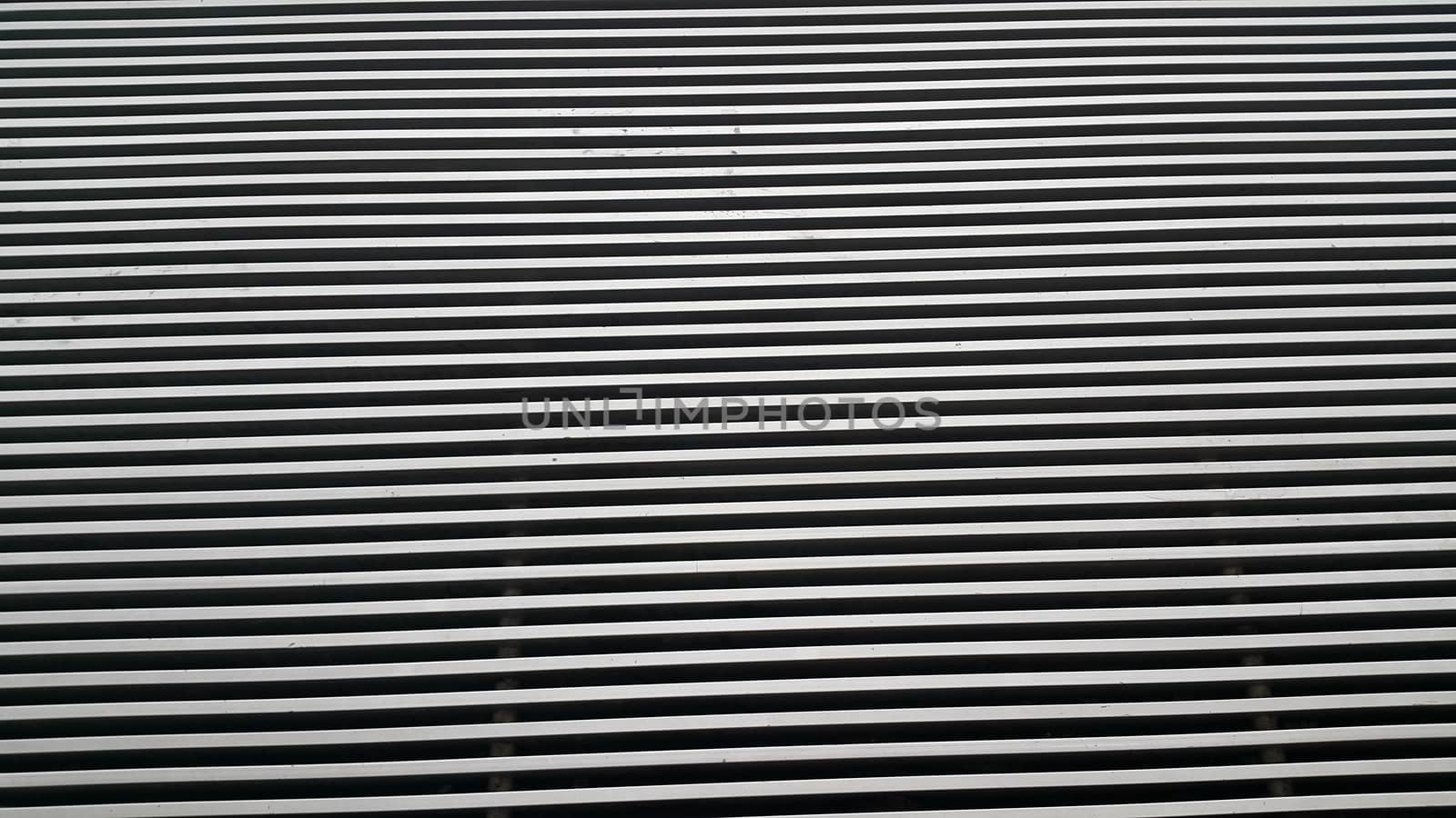 Close up view of shiny metal stripes background of interior walls and floor texture. The metal stripes repeatedly arranged to make wall or floor design.