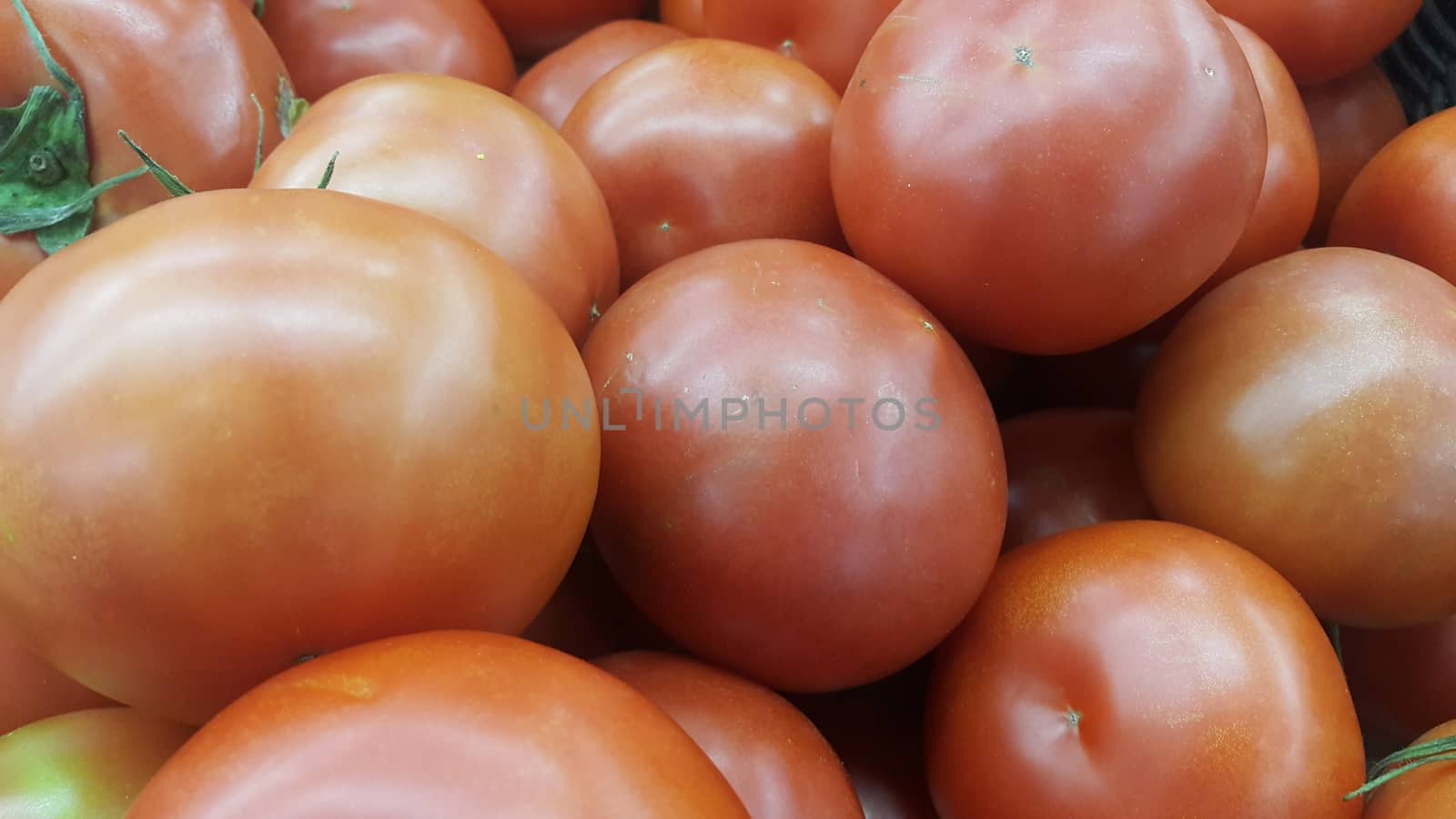 Red tomatoes in red basket in market for sale. A fruit background for text and advertisements