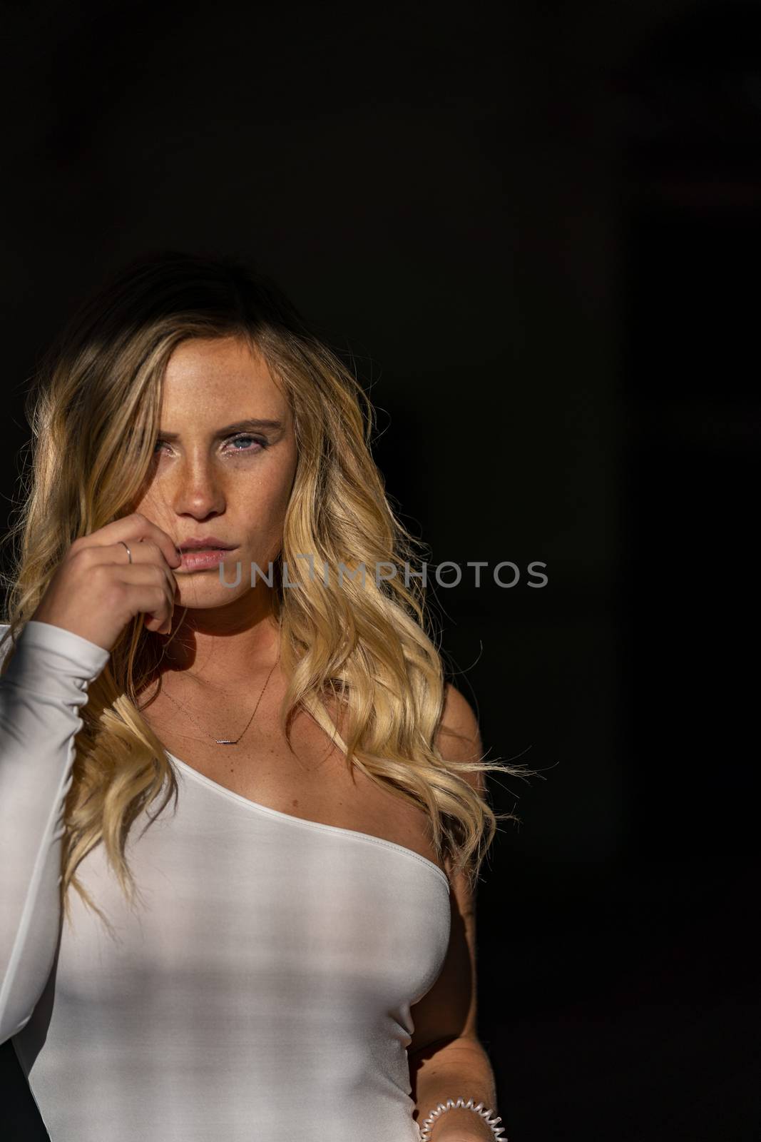 A gorgeous blonde model poses in a parking deck on an autumn day