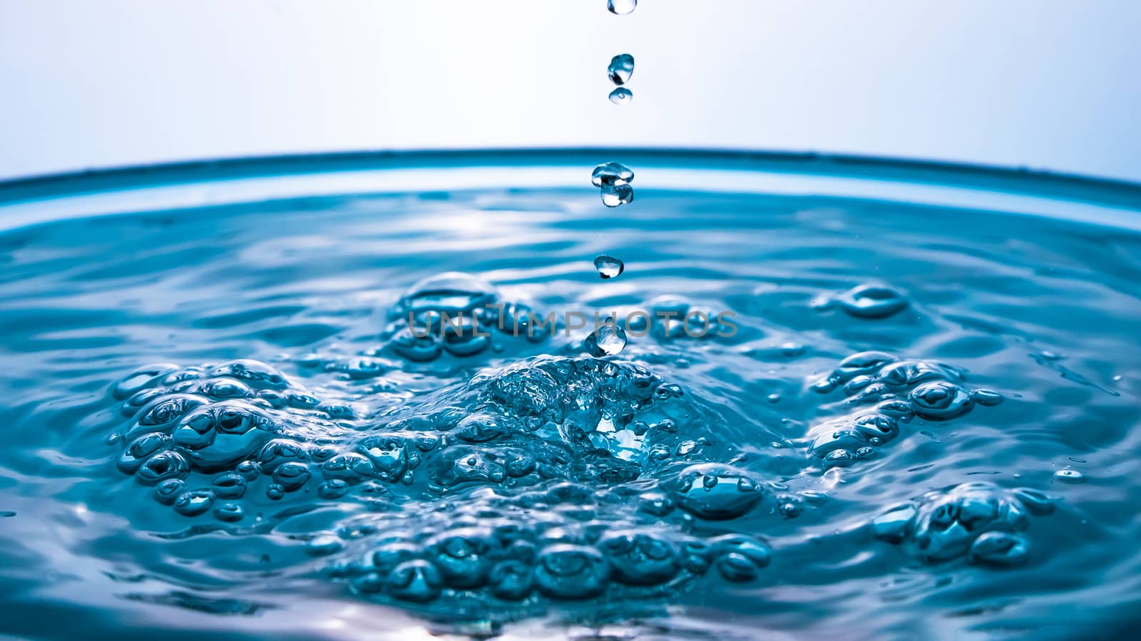 Abstract an outbreak of water. Splash of water close-up. Frozen water drop photographed at high speed.Slow dripping of liquid with air bubbles. Nature backgrounds or Wallpaper.Frozen liquid splashes