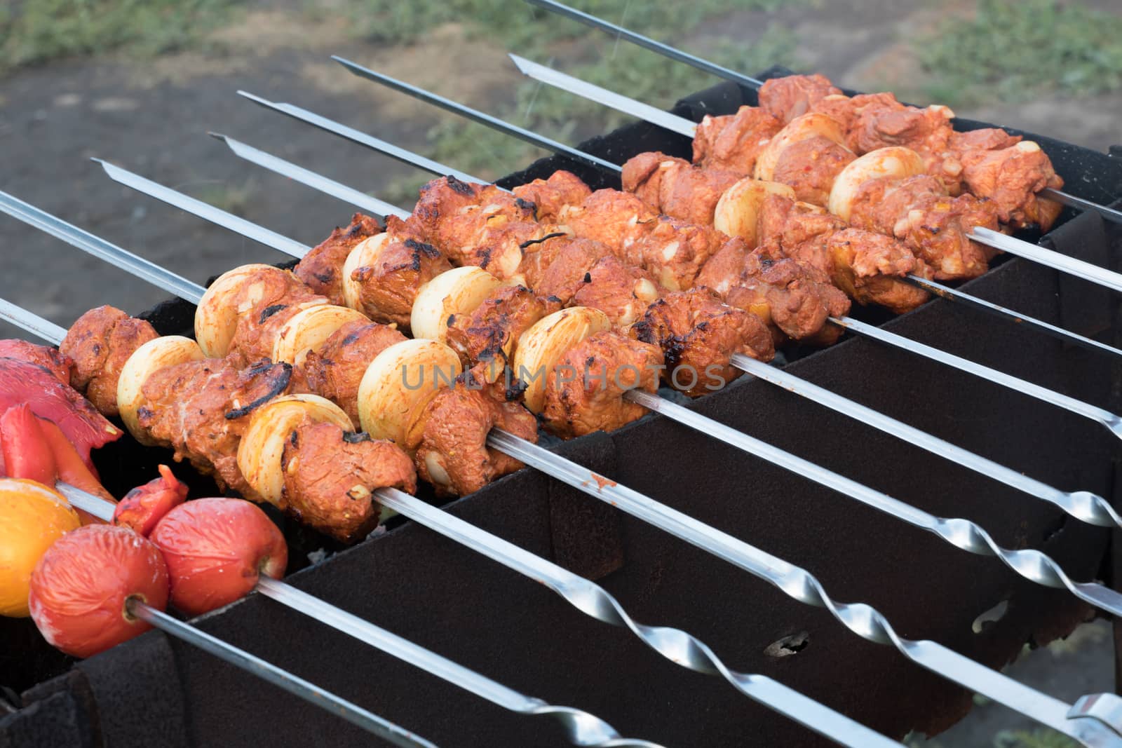 Photo cooking fry shish kebab,BBQ, barbecue, shashlik or meat on coals. Cooking meat in the grill on skewers in nature in the summer on a picnic. Pork on the grill