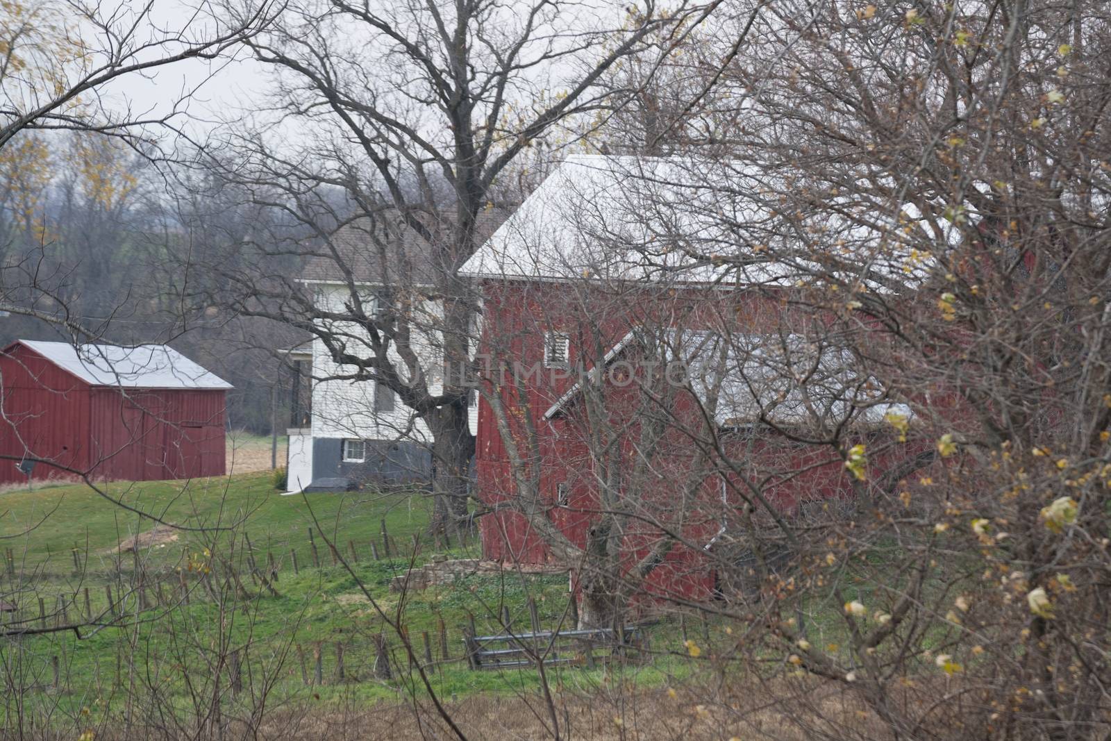 This is a farm that is revealed in the fall when the leaves are off the trrees.