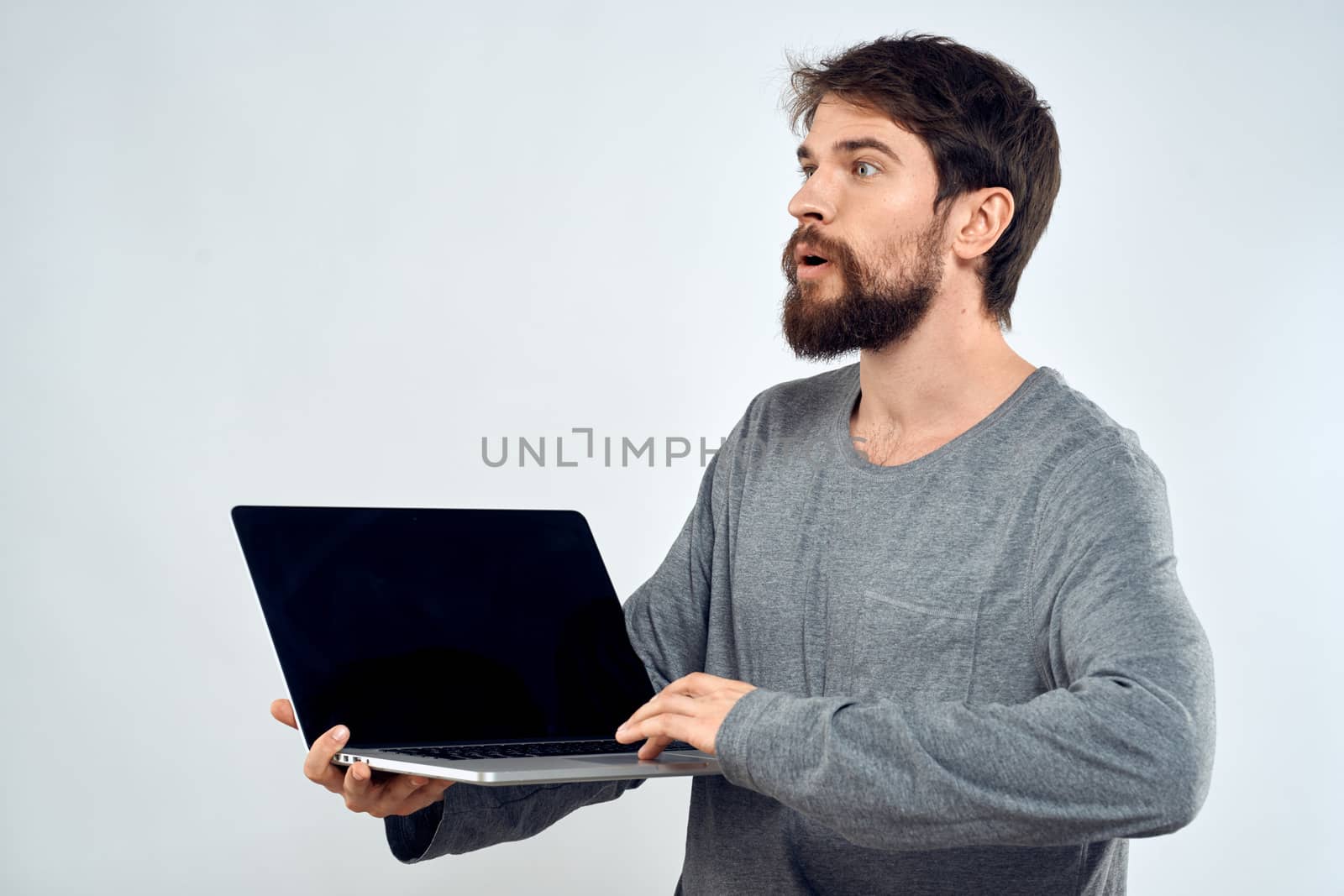 A man in a gray sweater with a laptop hands lifestyle technology communication internet work. High quality photo