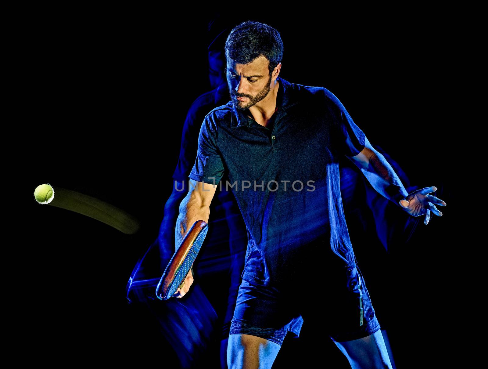 one caucasian Paddle tennis player man studio shot isolated on black background with light painting blur effect