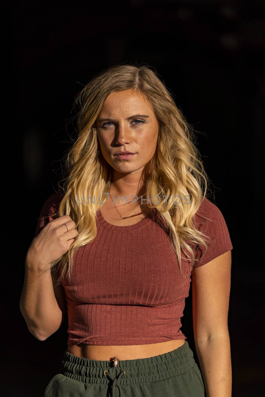 A gorgeous blonde model poses in a parking deck on an autumn day