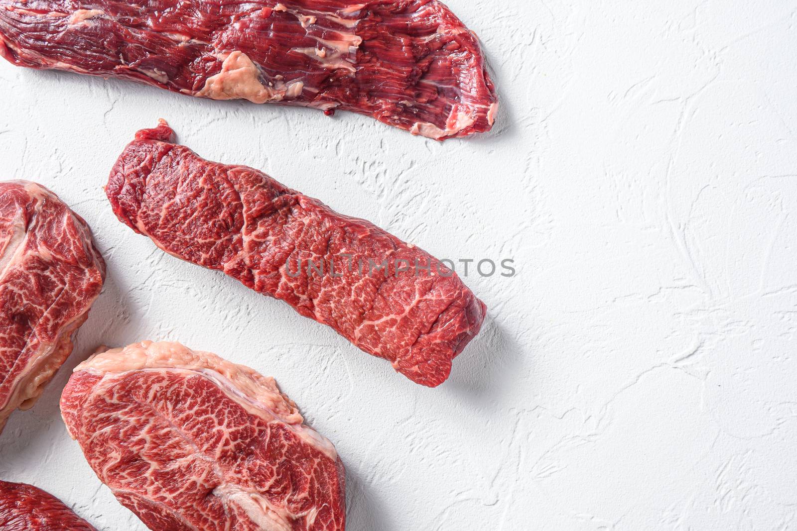 Raw organic machete steak near denver and top blade marble beef on white background top view space for text.