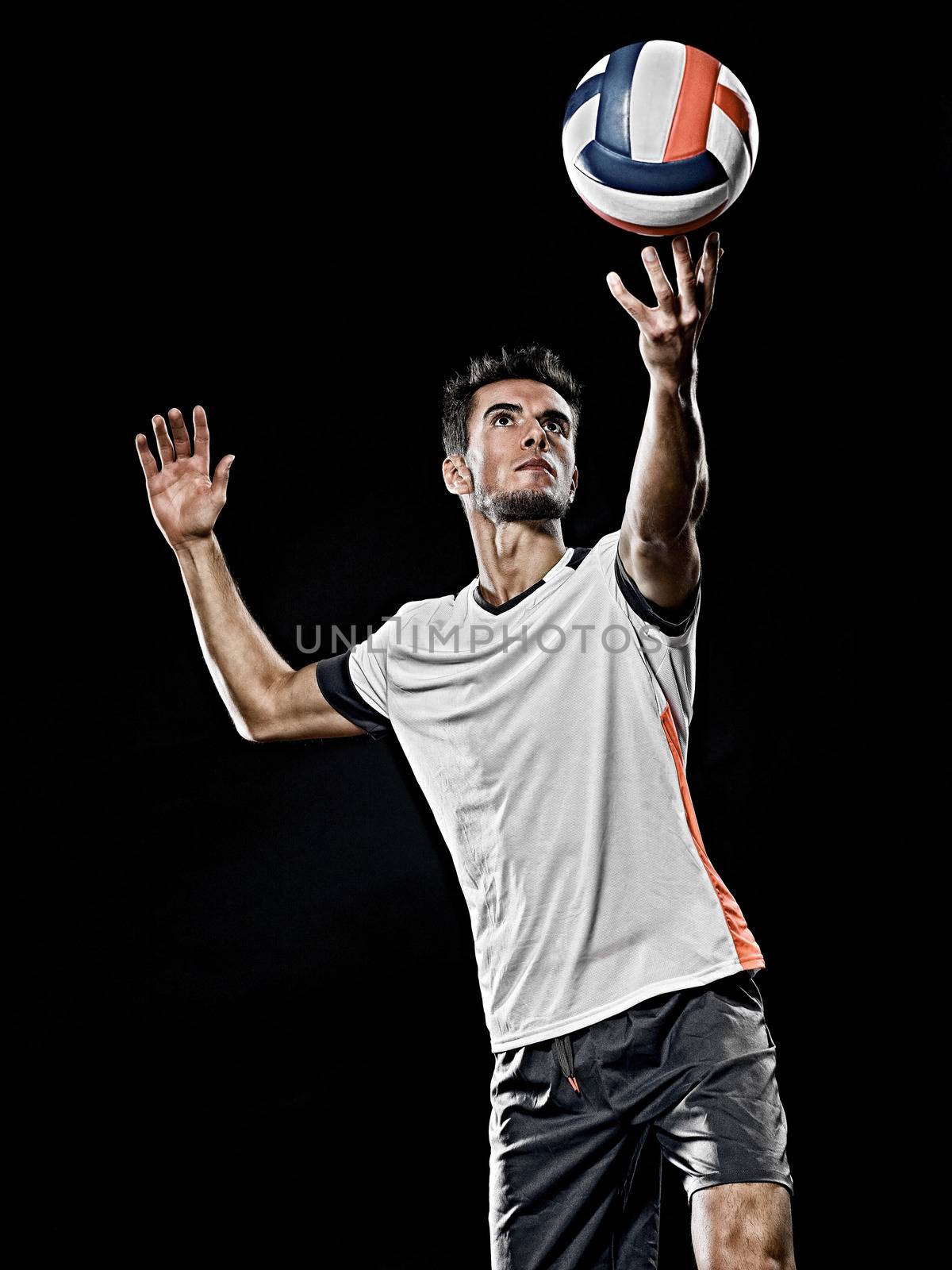one caucasian young volley ball player man in studio isolated on black background