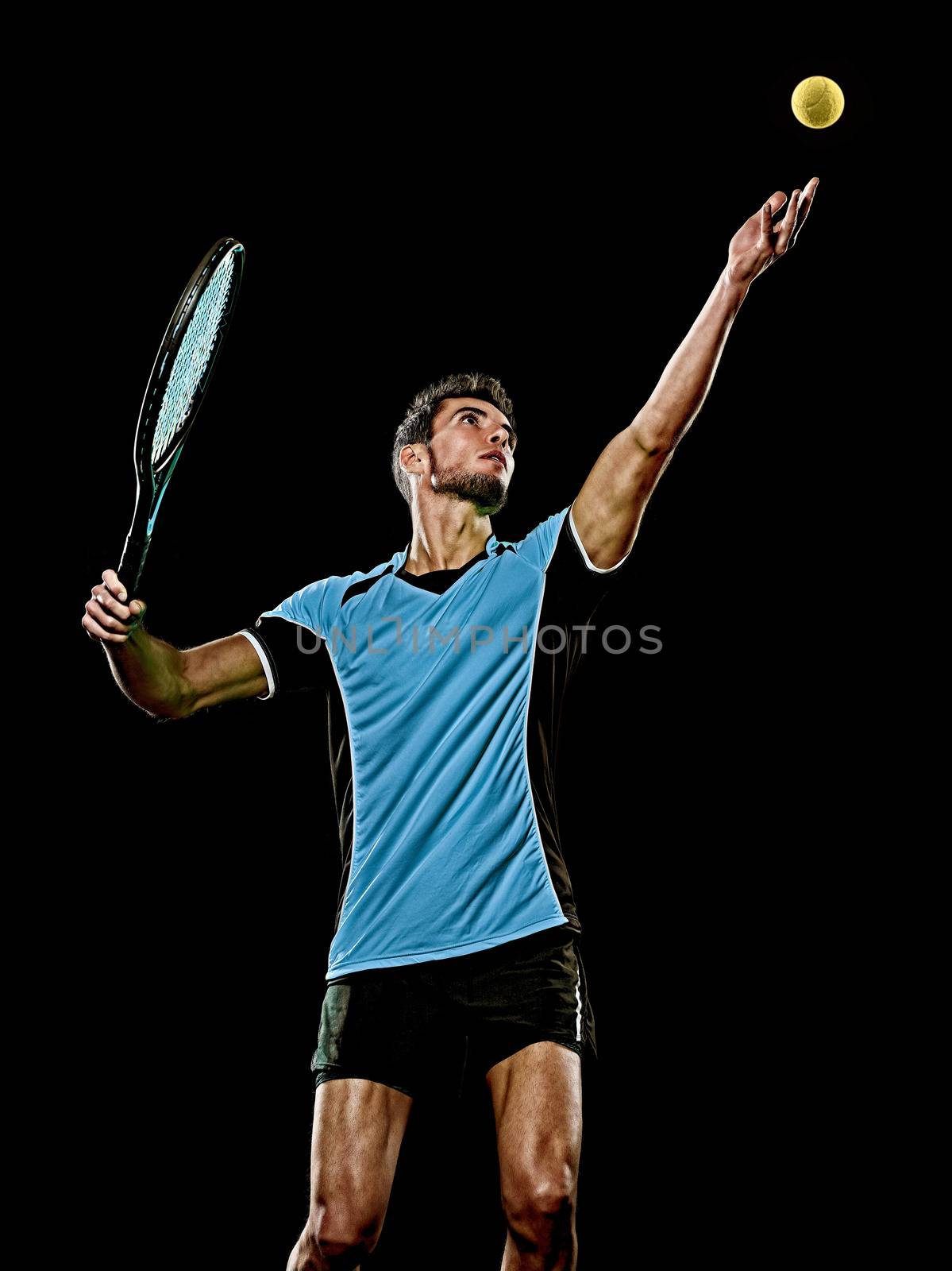 one caucasian young player tennis man in studio isolated on black background