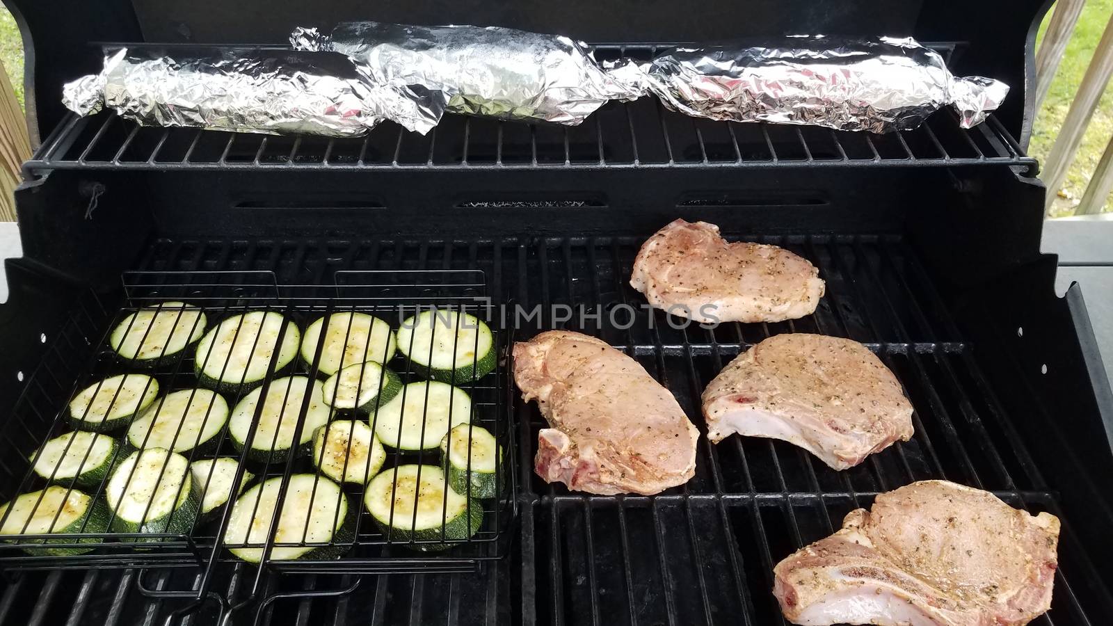 zucchini and pork chops on barbecue grill with corn by stockphotofan1