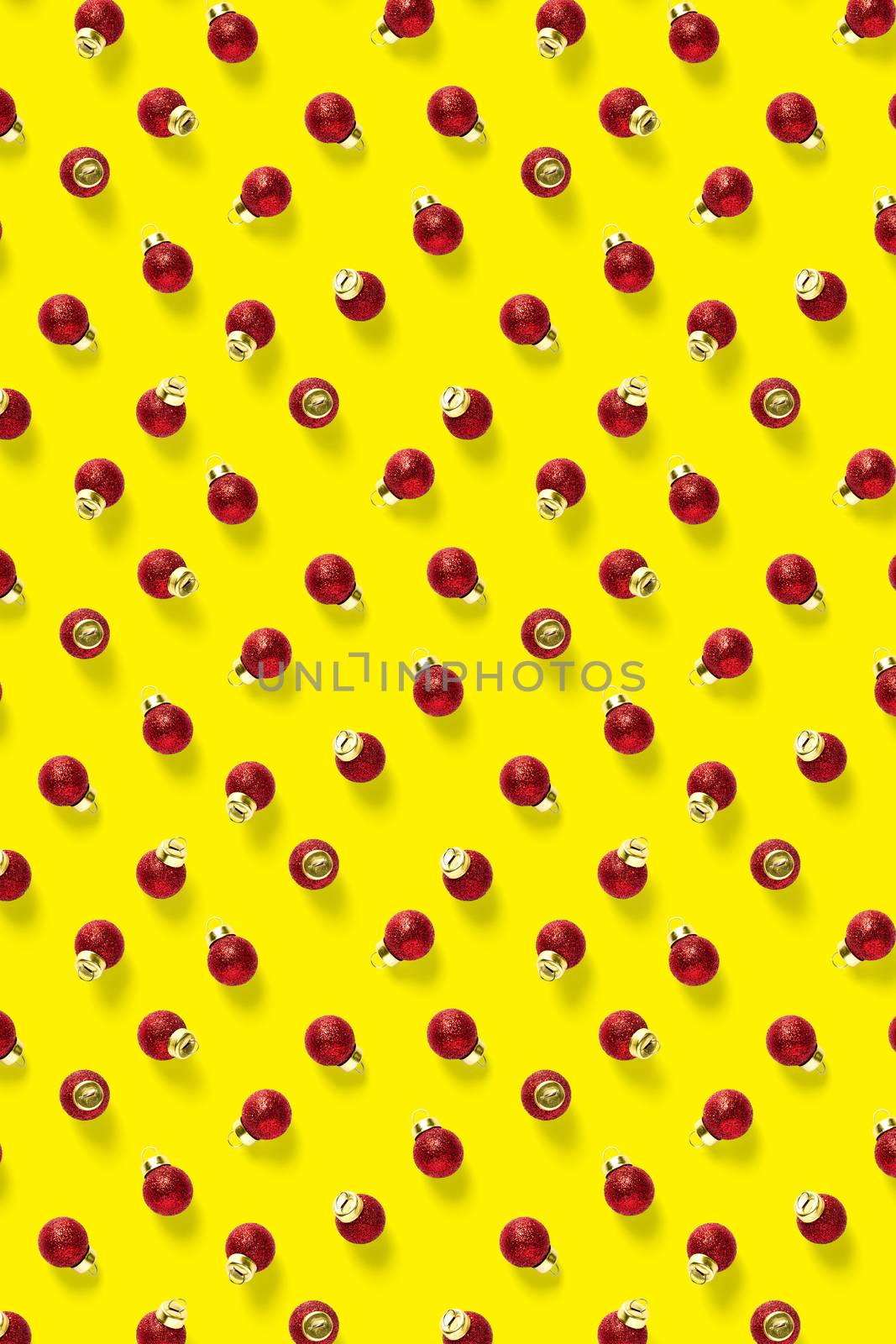 Christmas red decorations on yellow background. Christmas ornaments composition for background. Flat lay background madefrome red ornaments decorations