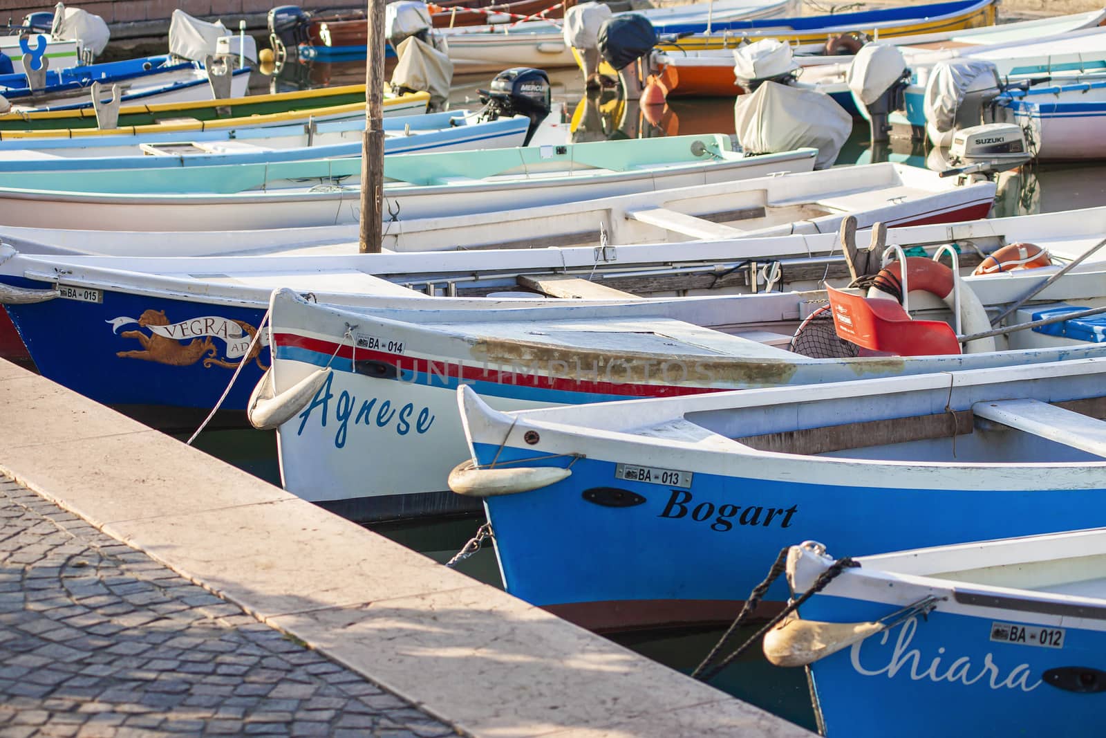 BARDOLINO, ITALY 16 SEPTEMBER 2020: Colored boats moored on Bardolino port in Italy