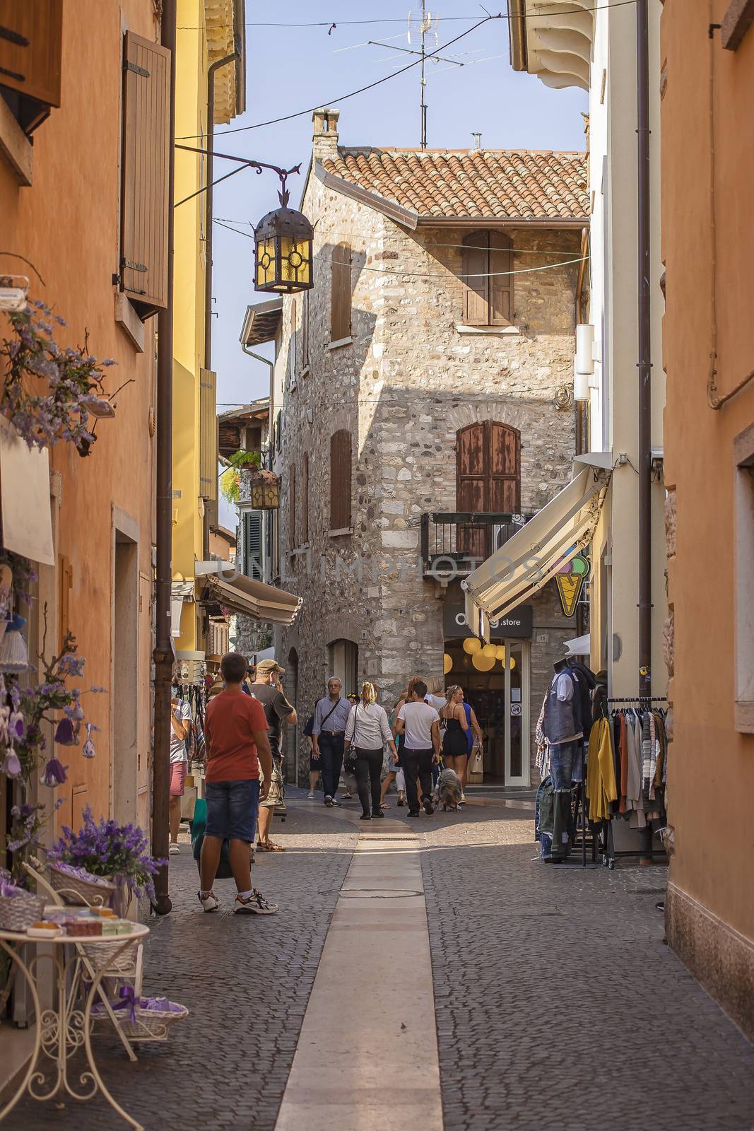 Alley with people and tourists walking in Lazise in Italy by pippocarlot