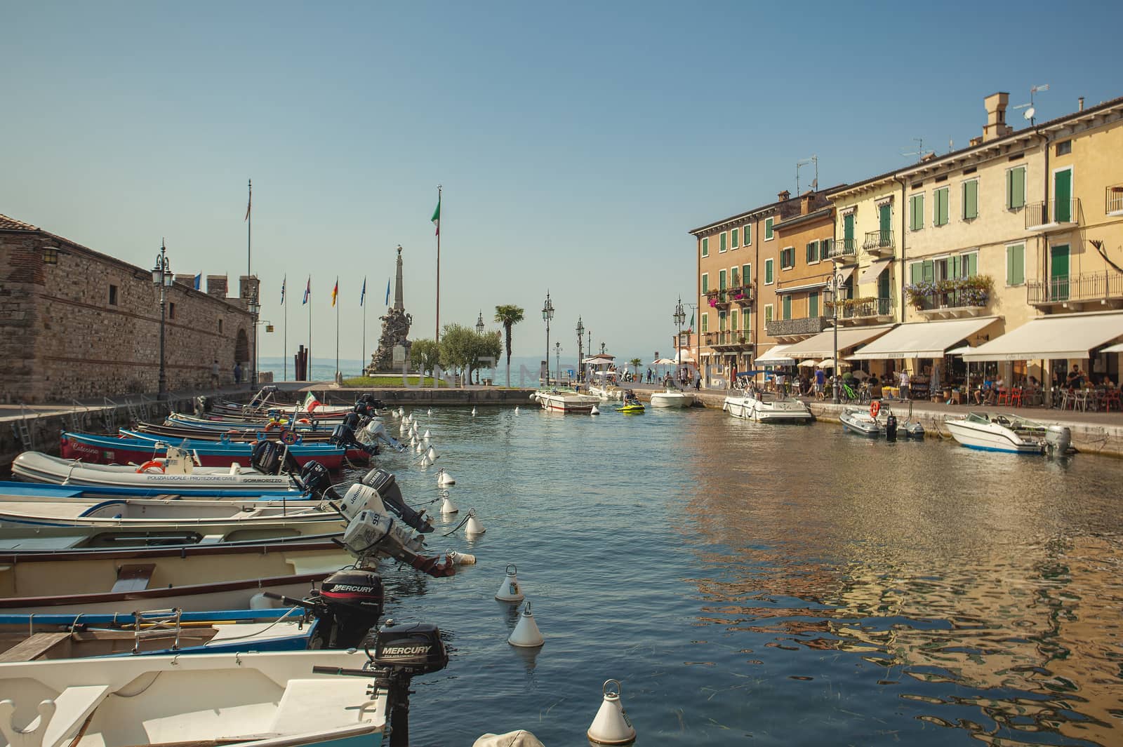 Dogana Veneta and Porticciolo in Lazise, in Italy with colored boats by pippocarlot
