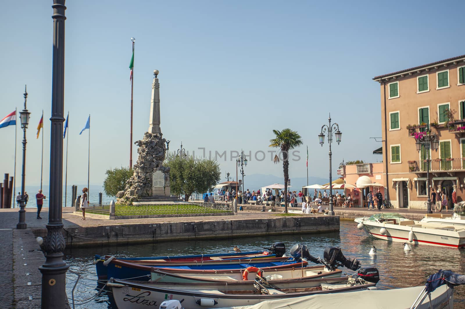 LAZISE, ITALY 16 SEPTEMBER 2020: Dogana Veneta and Porticciolo in Lazise, in Italy with colored boats