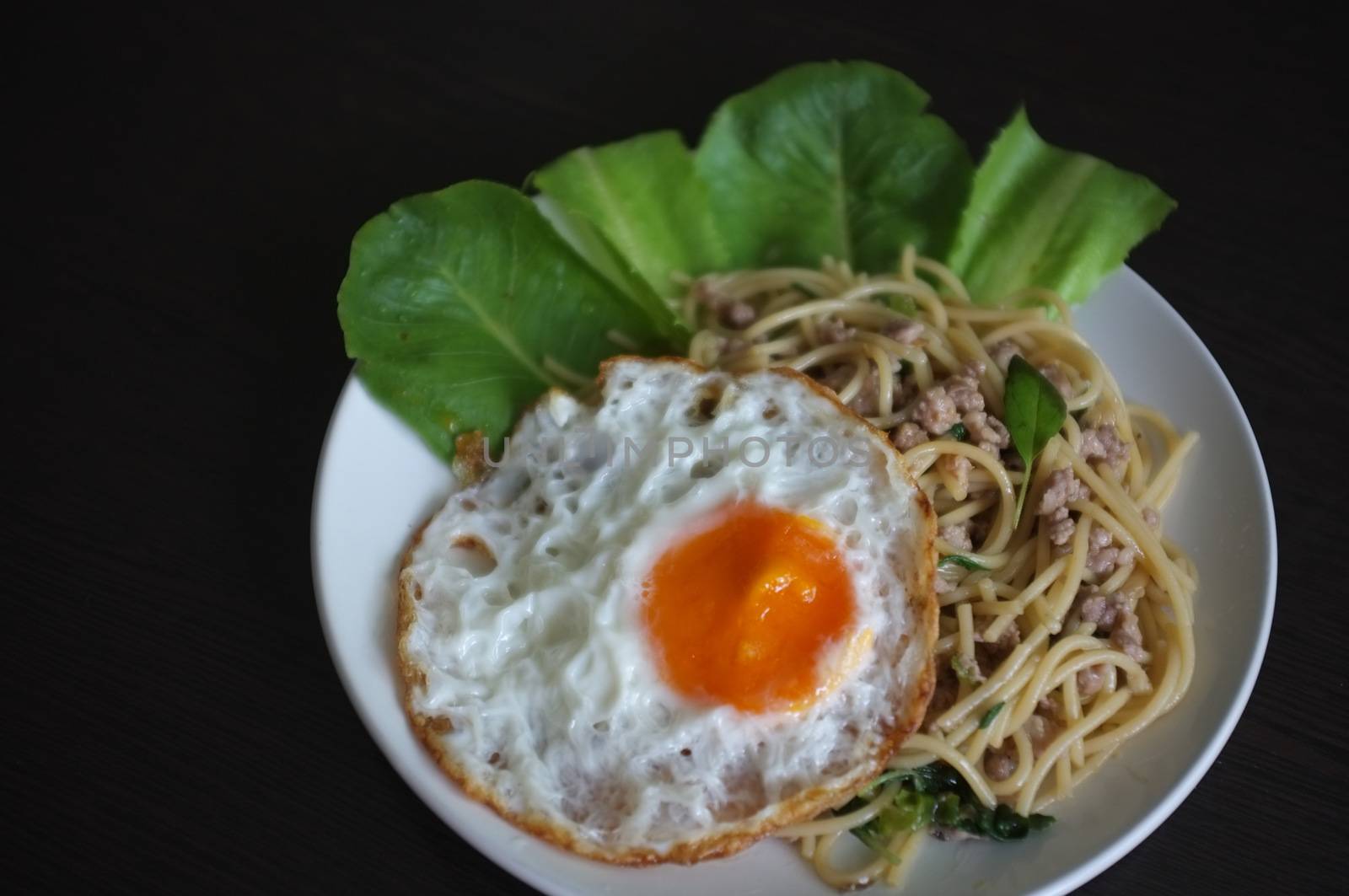 Spaghetti stir fried with Thai Basil spicy sauce with Fried egg  , fusion Thai style , space for text