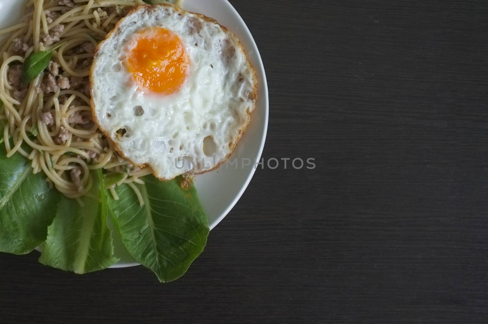 Spaghetti stir fried with Thai Basil spicy sauce with Fried egg  , fusion Thai style , space for text