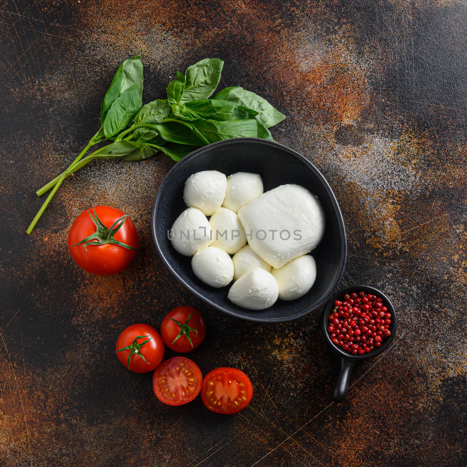 Mini balls of mozzarella cheese, ingredients for salad Caprese. on old rustic metal background. Caprese salad ingredients. Selective focus. top view square space for text. by Ilianesolenyi