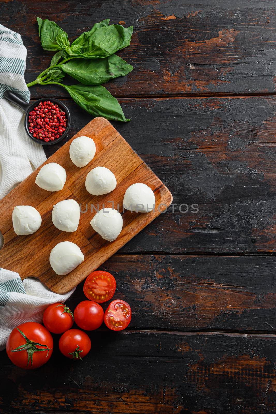 Fresh cherry tomatoes, basil leaf, mozzarella cheese on old wood background table space for text vertical by Ilianesolenyi