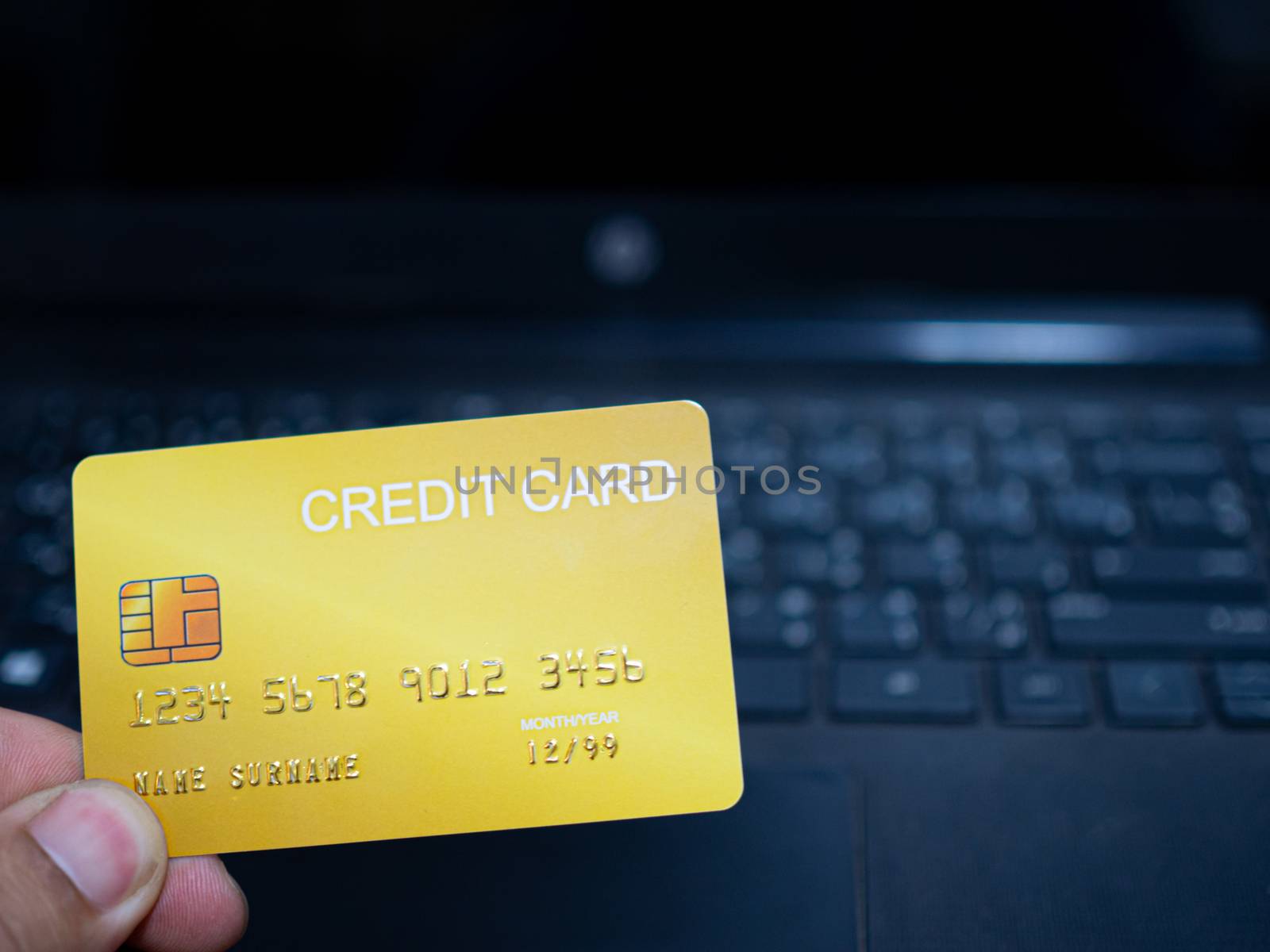 Online shopping concept. Close-up human hands holding a credit card on notebook background. by Unimages2527