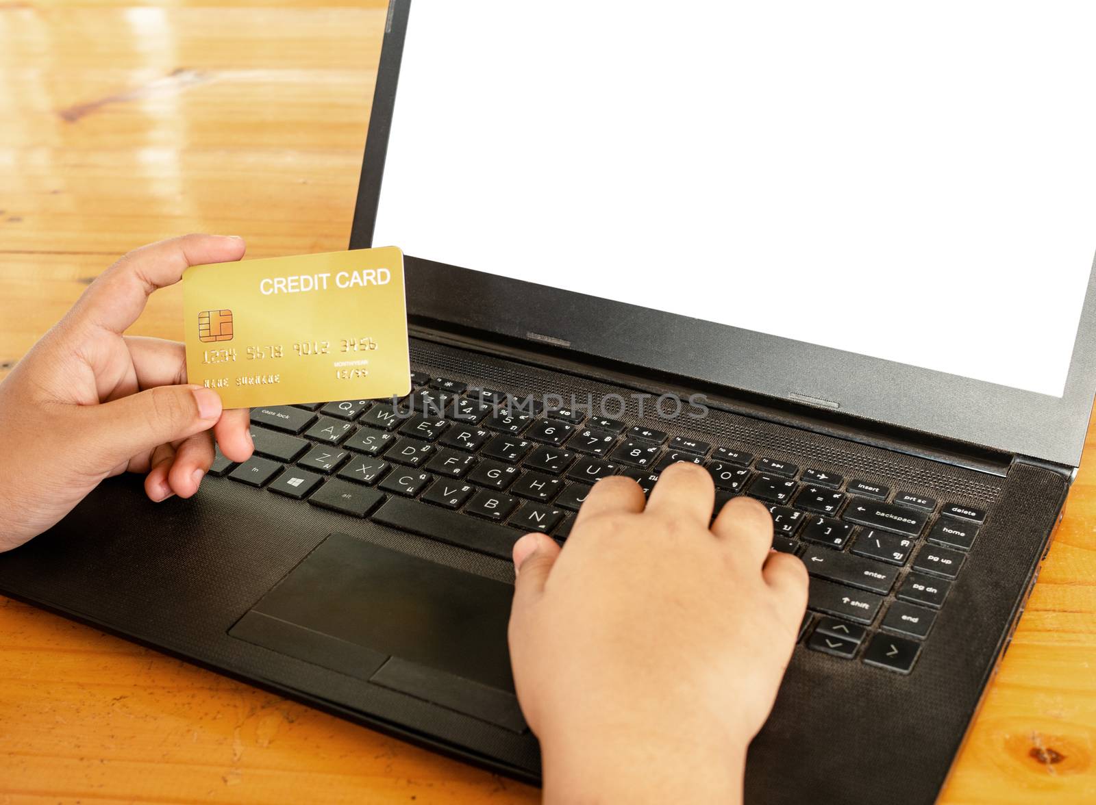 Close-up human hands holding a credit card and using computer. online shopping concept. by Unimages2527