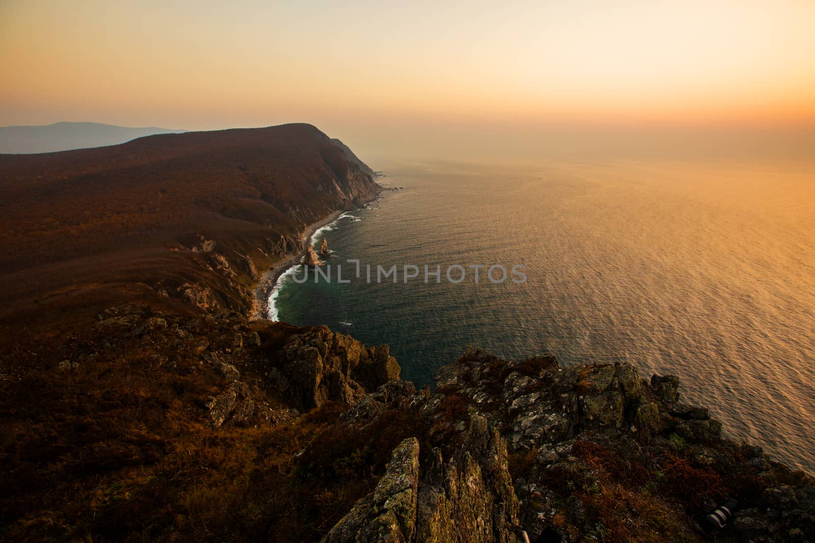 Panoramic view of the rocky coastline of the nature reserve during pink sunrise