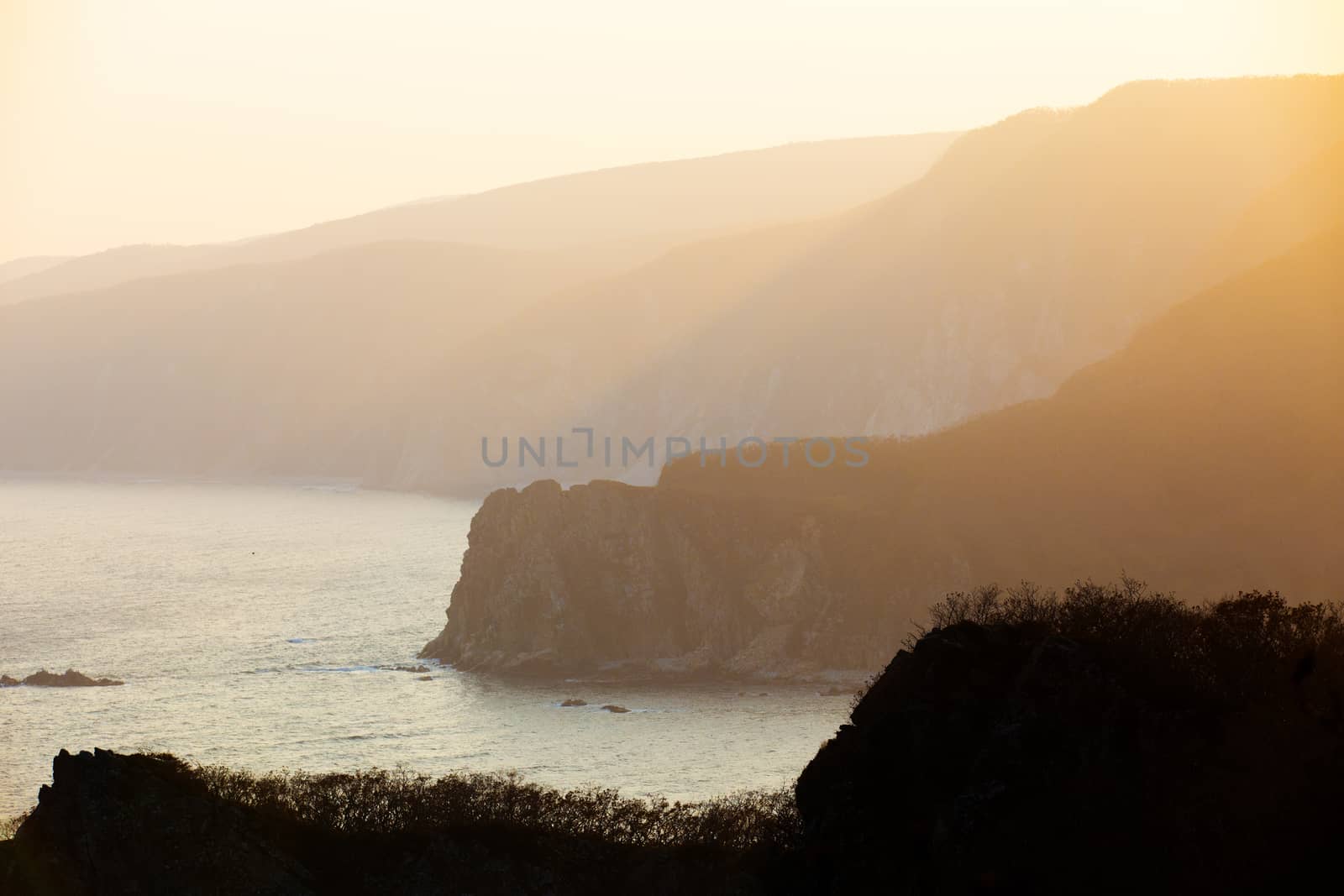 The rays of the setting sun make their way through the rocky coast of the reserve