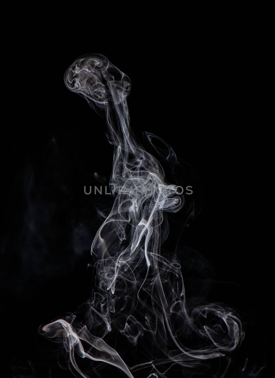 Conceptual image of white color smoke isolated on dark black bac by ROMIXIMAGE